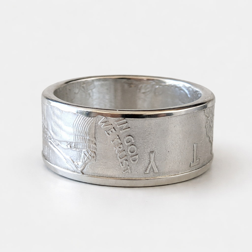 Polished American Silver Eagle coin ring laying flat with the In Got We Trust motto facing out.