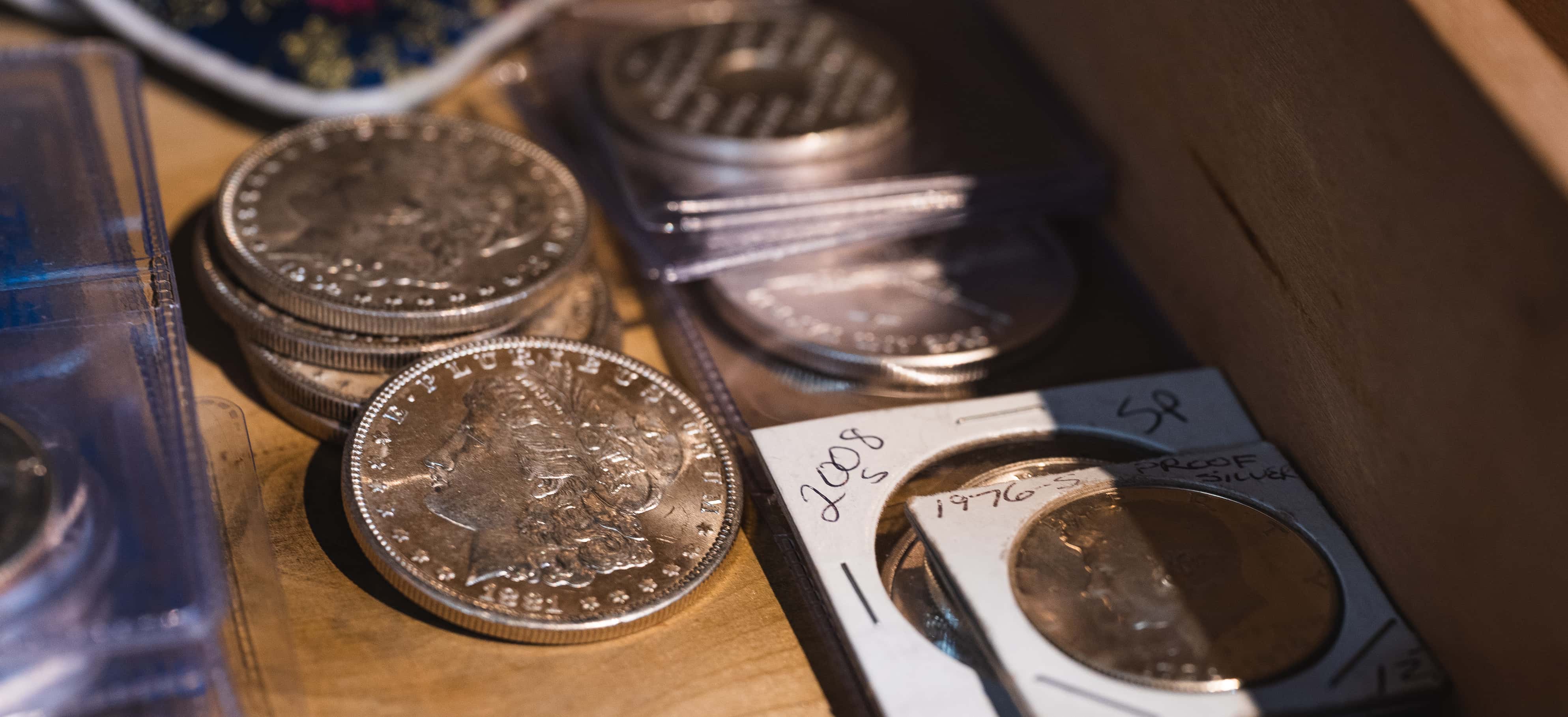 Antique coins in a wooden safe drawer