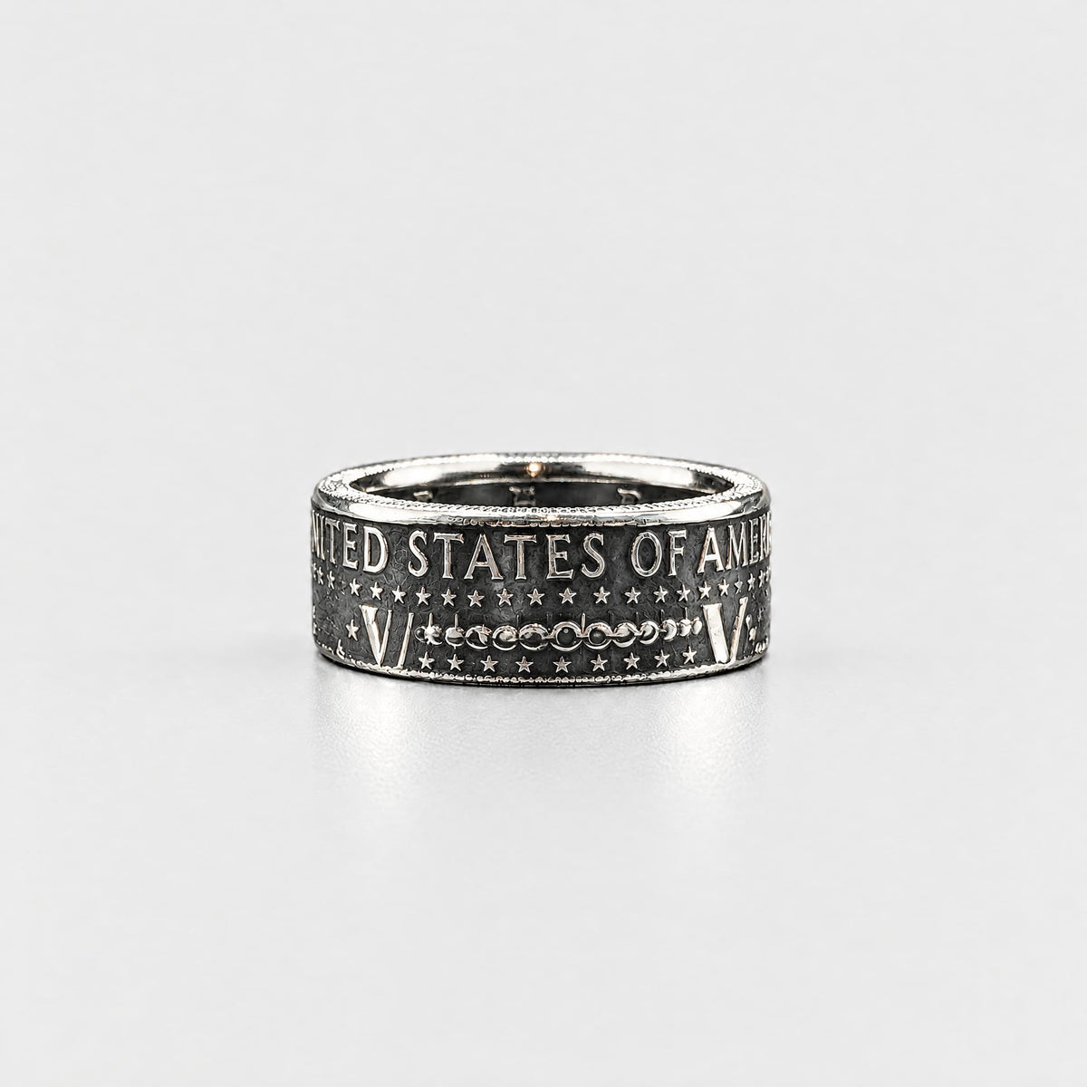 JFK half dollar coin ring laying flat with a patina finish from Silver State Foundry