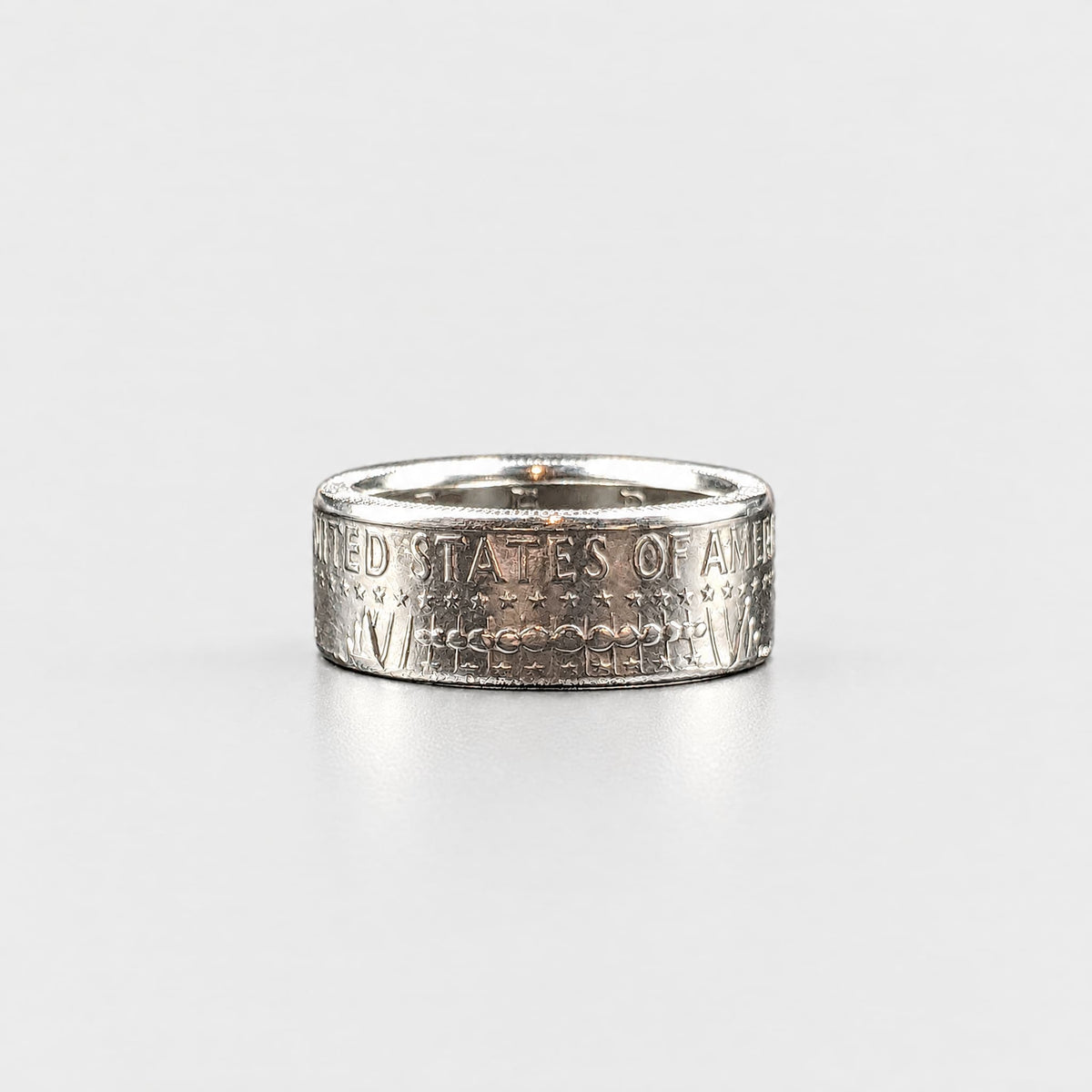 JFK half dollar coin ring laying flat with a polished finish from Silver State Foundry