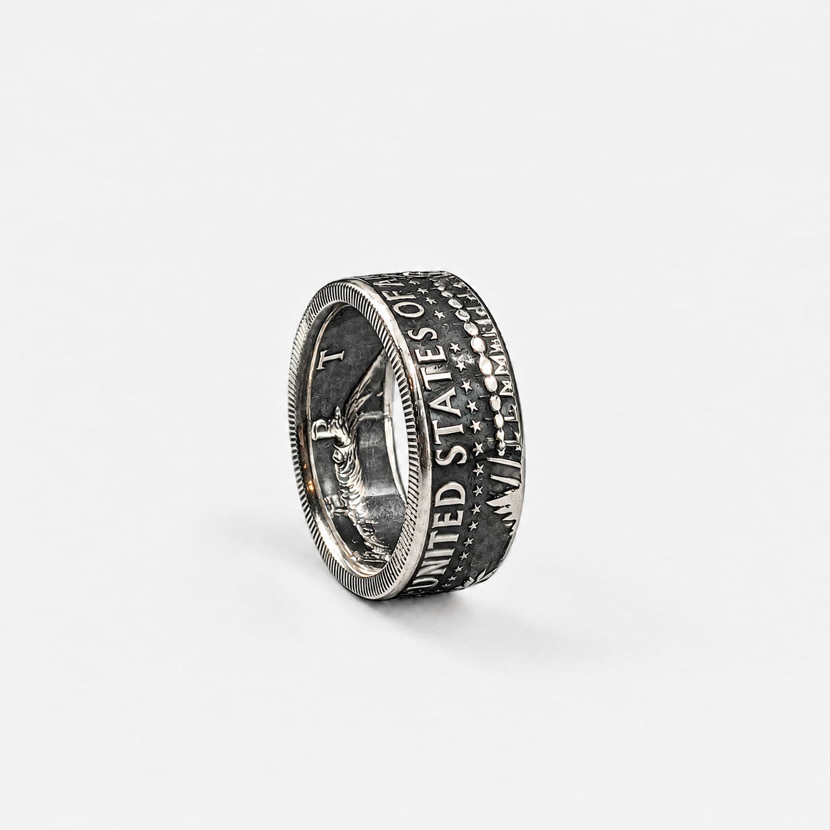 JFK half dollar coin ring standing on edge with a patina finish from Silver State Foundry