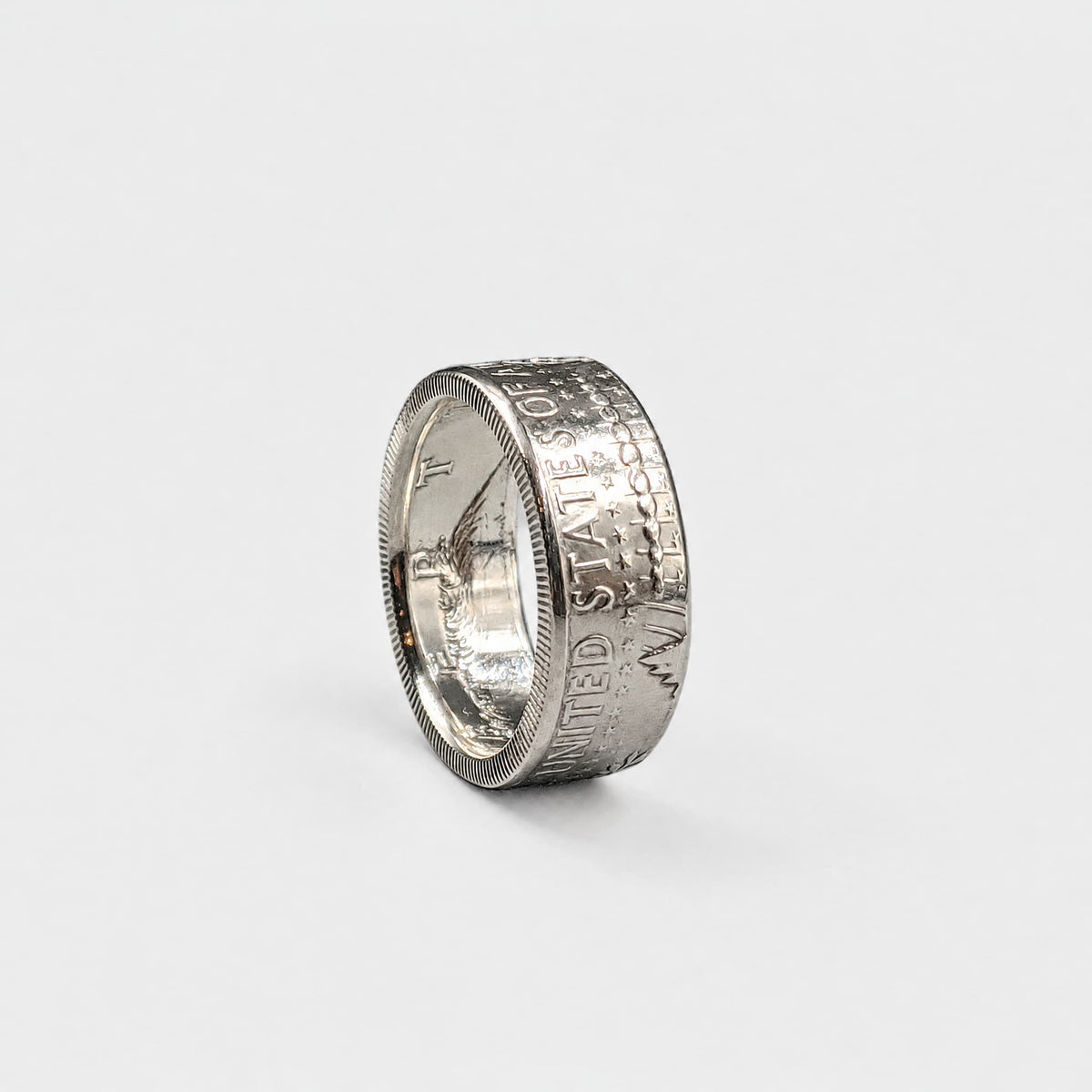 JFK half dollar coin ring standing on edge with a polished finish from Silver State Foundry