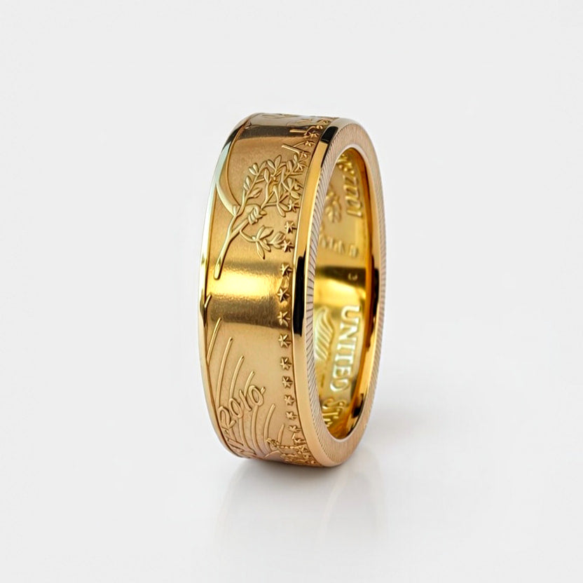 Gold coin ring forged from a half ounce American Gold Eagle coin, standing on edge and showing the date on a white background.