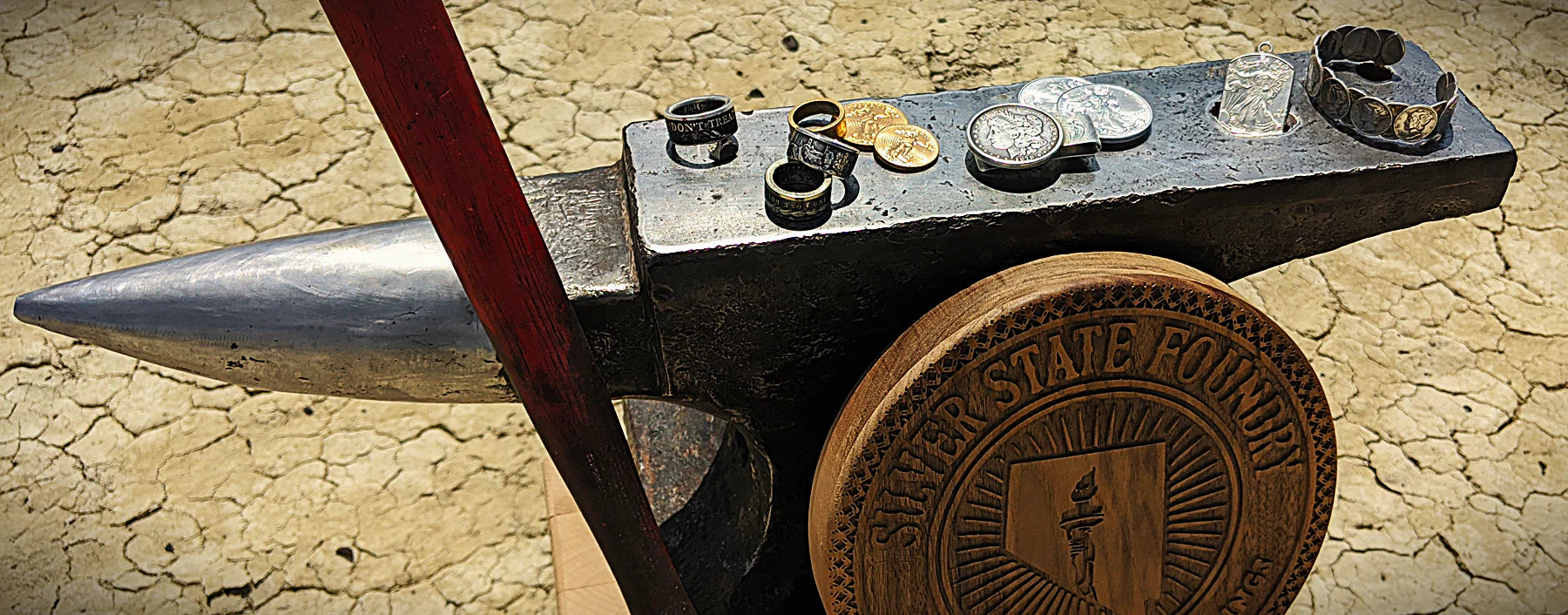 Anvil in the desert with gold and silver jewelry resting on it