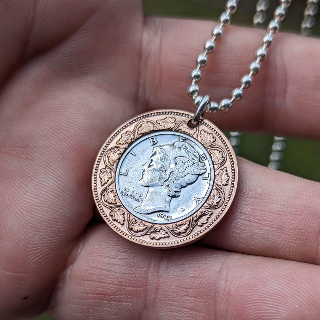 Bullseye pendant on a sterling ball chain displayed laying in the palm of a hand.