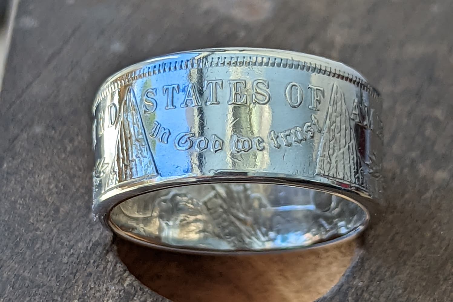 Polished Morgan Silver Dollar coin ring on a bench pin