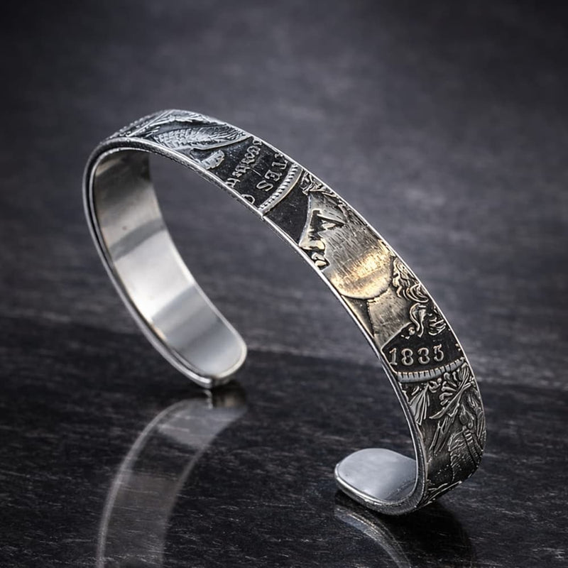 Morgan Silver Dollar striped cuff bracelet laying on a dark surface.