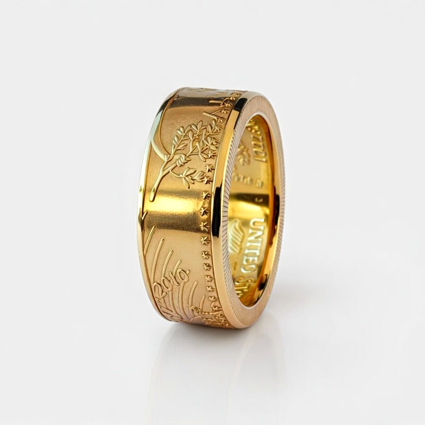 Gold ring forged from a full ounce American Gold Eagle coin, standing on edge and showing the date on a white background.