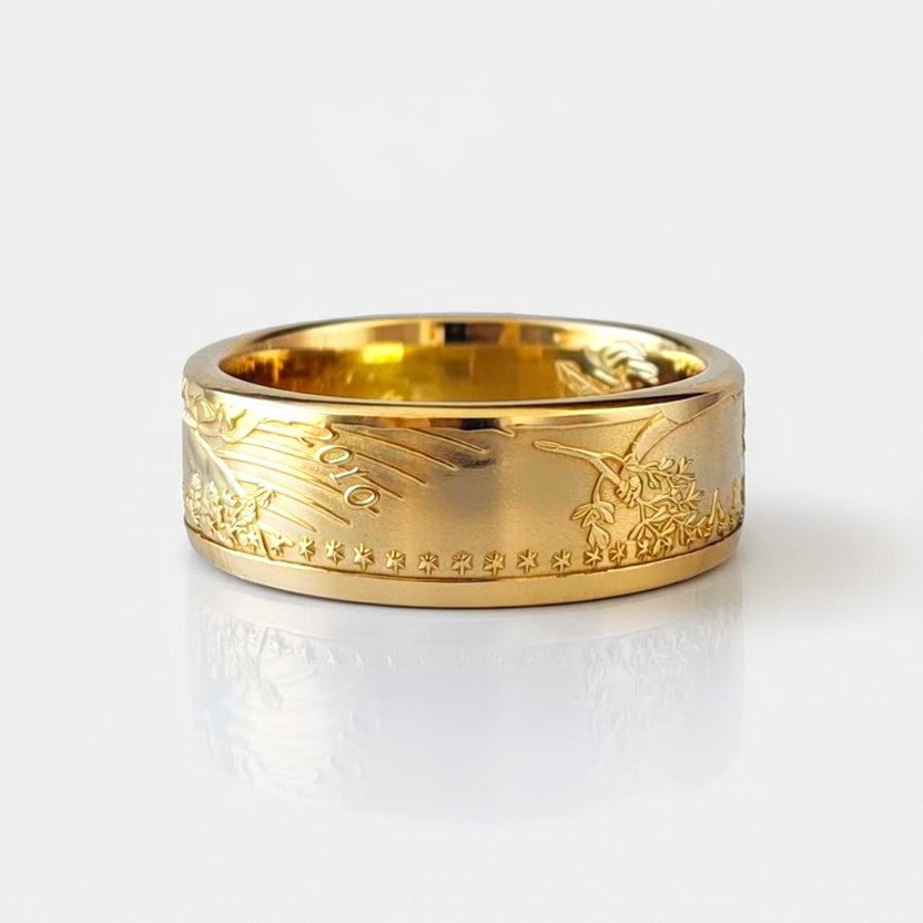Gold coin ring forged from a half ounce American Gold Eagle coin, laying flat and showing the date on a white background.
