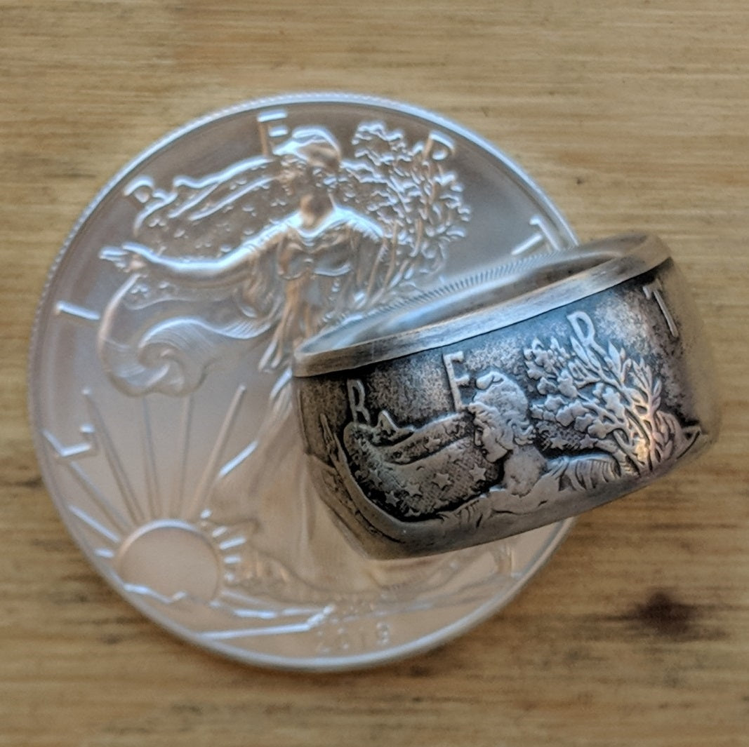 Fat Tire shaped Silver Eagle Coin Ring with patina resting on a Silver Eagle coin.